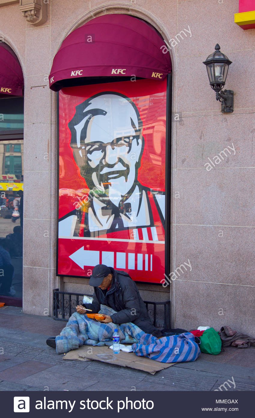 a-homeless-man-sitting-on-the-pavement-outside-a-kfc-restaurant-near-beijing-railway-station-i...jpg