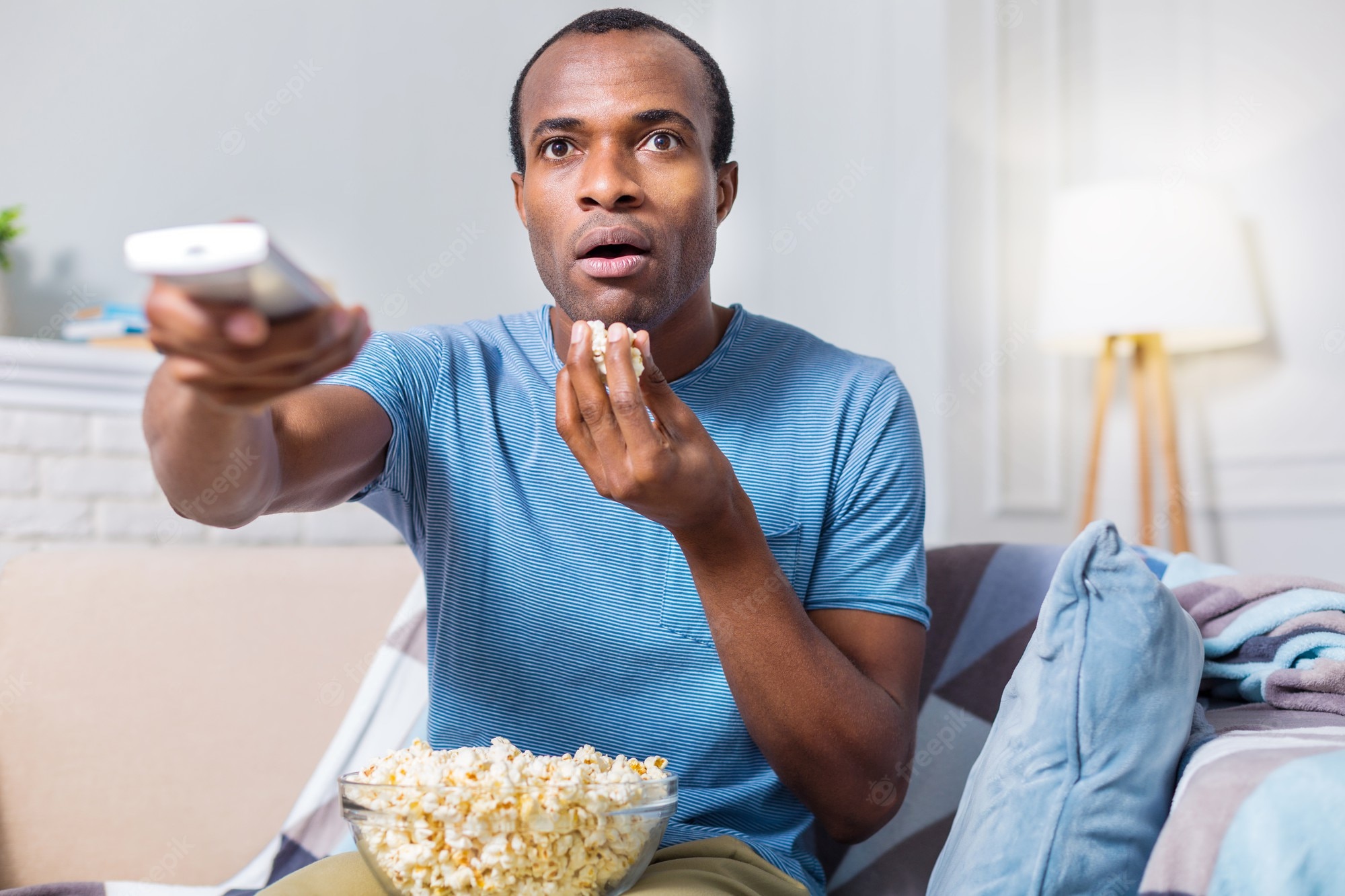 nice-astonished-handsome-man-eating-popcorn-being-involved-movie-while-watching-tv_259150-24288.jpg