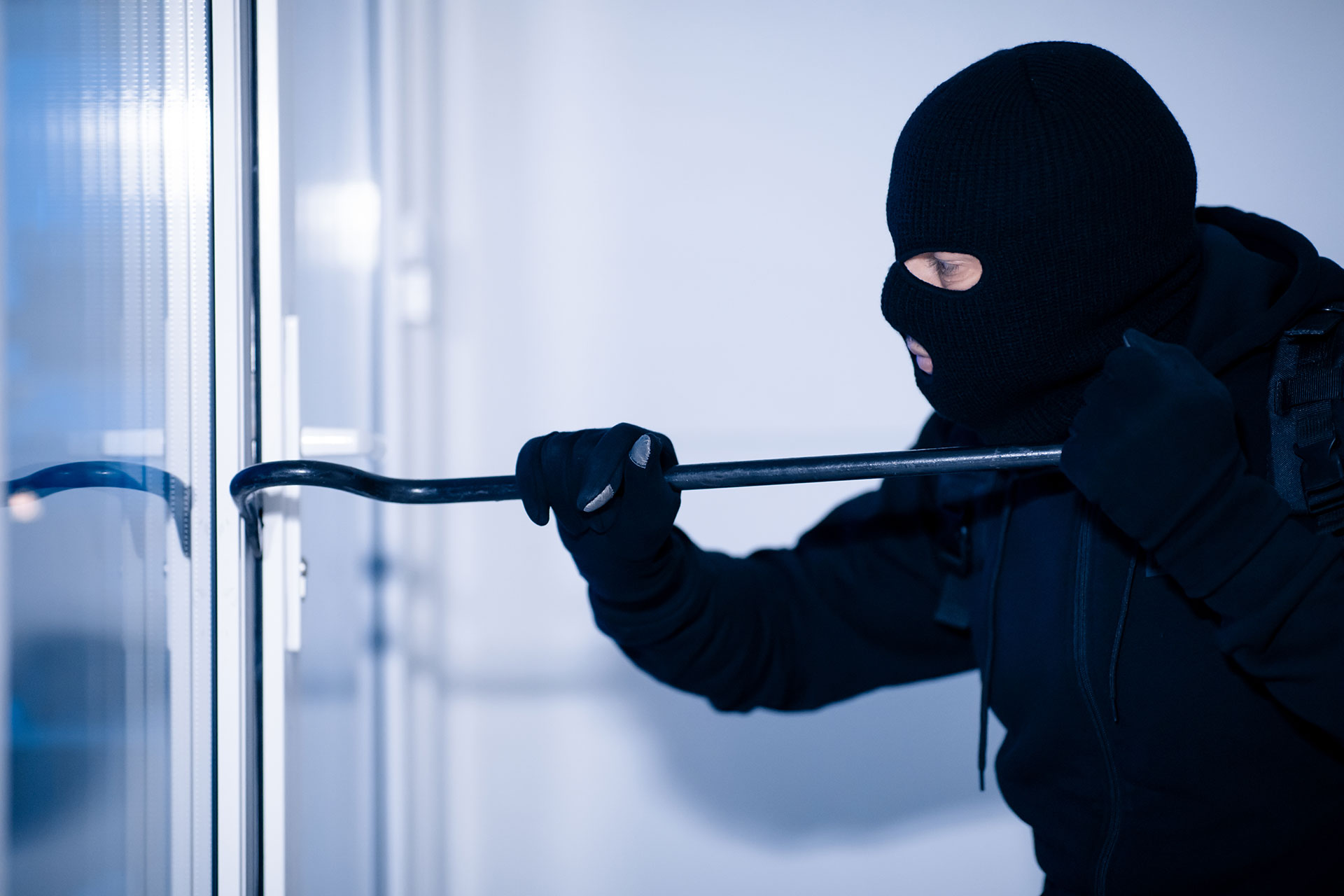 robber-in-black-balaclava-cracking-door-with-crow.jpg